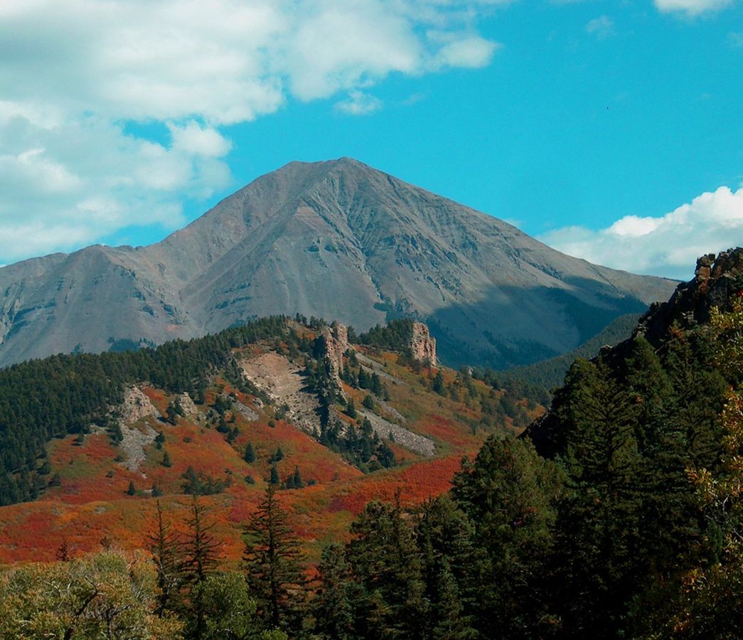 West Spanish Peak with red and orange scrub oak at the
base of the igneous dikes along the Scenic Highway of
Legends
